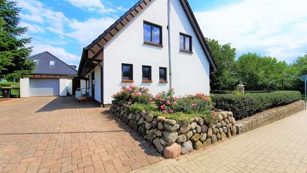 Seitenansicht mit Zufahrt und Garage - Einfamilienhaus in 25879 Stapel mit 169m² kaufen