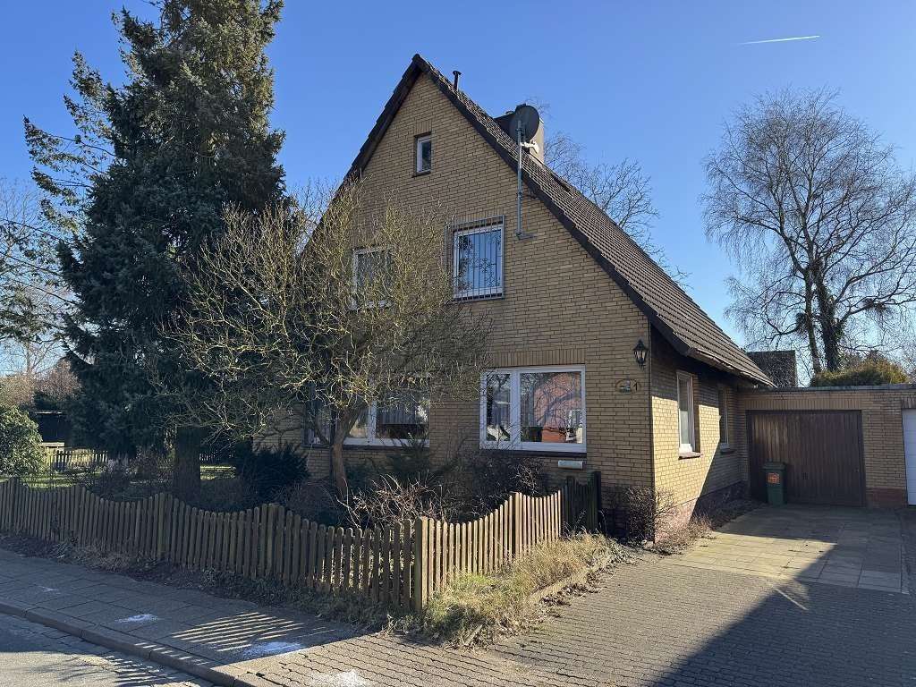 Seitenansicht mit Auffahrt & Garage - Einfamilienhaus in 25746 Heide mit 120m² kaufen