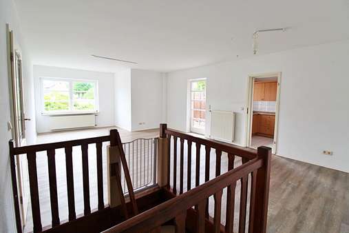 Wohnzimmer mit Holztreppe - Etagenwohnung in 21266 Jesteburg mit 120m² günstig kaufen