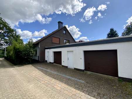 seitliche Ansicht mit Garagen - Zweifamilienhaus in 30938 Burgwedel mit 254m² kaufen