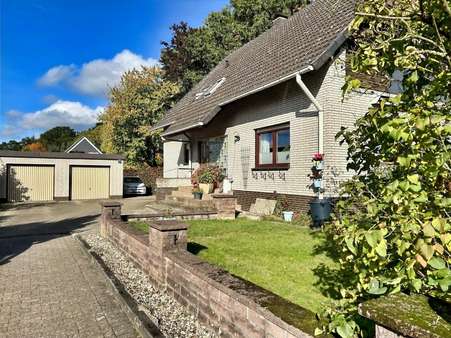 Seitliche Hausansicht mit Hofeinfahrt und Doppelgarage Seitliche Hausansicht mit Hofeinfahrt und Doppelgarage - Zweifamilienhaus in 29664 Walsrode mit 169m² kaufen