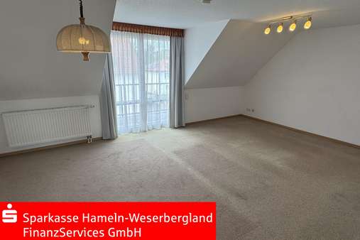 Wohnzimmer mit Balkon - Dachgeschosswohnung in 31840 Hessisch Oldendorf mit 72m² kaufen
