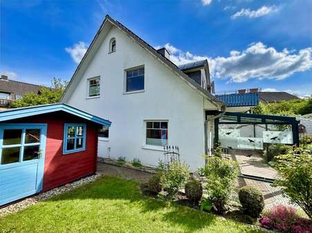 Blick auf das Gartenhaus, das Haus und die Terrasse - Doppelhaushälfte in 29549 Bad Bevensen mit 110m² kaufen