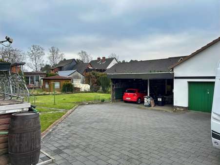 Blick auf Garage und Doppelcarport - Zweifamilienhaus in 29313 Hambühren mit 214m² kaufen