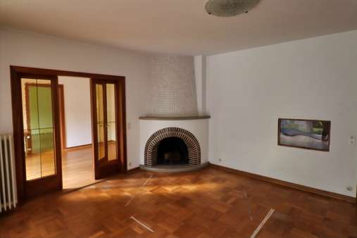 Wohnzimmer mit Kamin - Einfamilienhaus in 26160 Bad Zwischenahn mit 243m² günstig kaufen