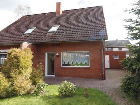 Terrassenansicht mit Eingang Garage - Doppelhaushälfte in 26676 Barßel mit 97m² günstig kaufen