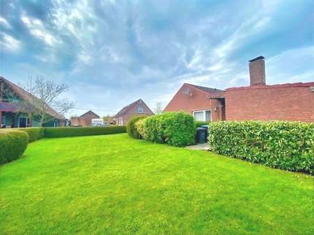 Das Haus ist von einer robusten Rasenfläche umgeben - Einfamilienhaus in 26434 Wangerland mit 79m² kaufen