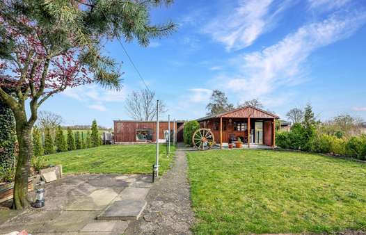 Blick auf den rückwärtigen Garten und einen Teil der Nebengebäude - Einfamilienhaus in 28832 Achim mit 150m² kaufen