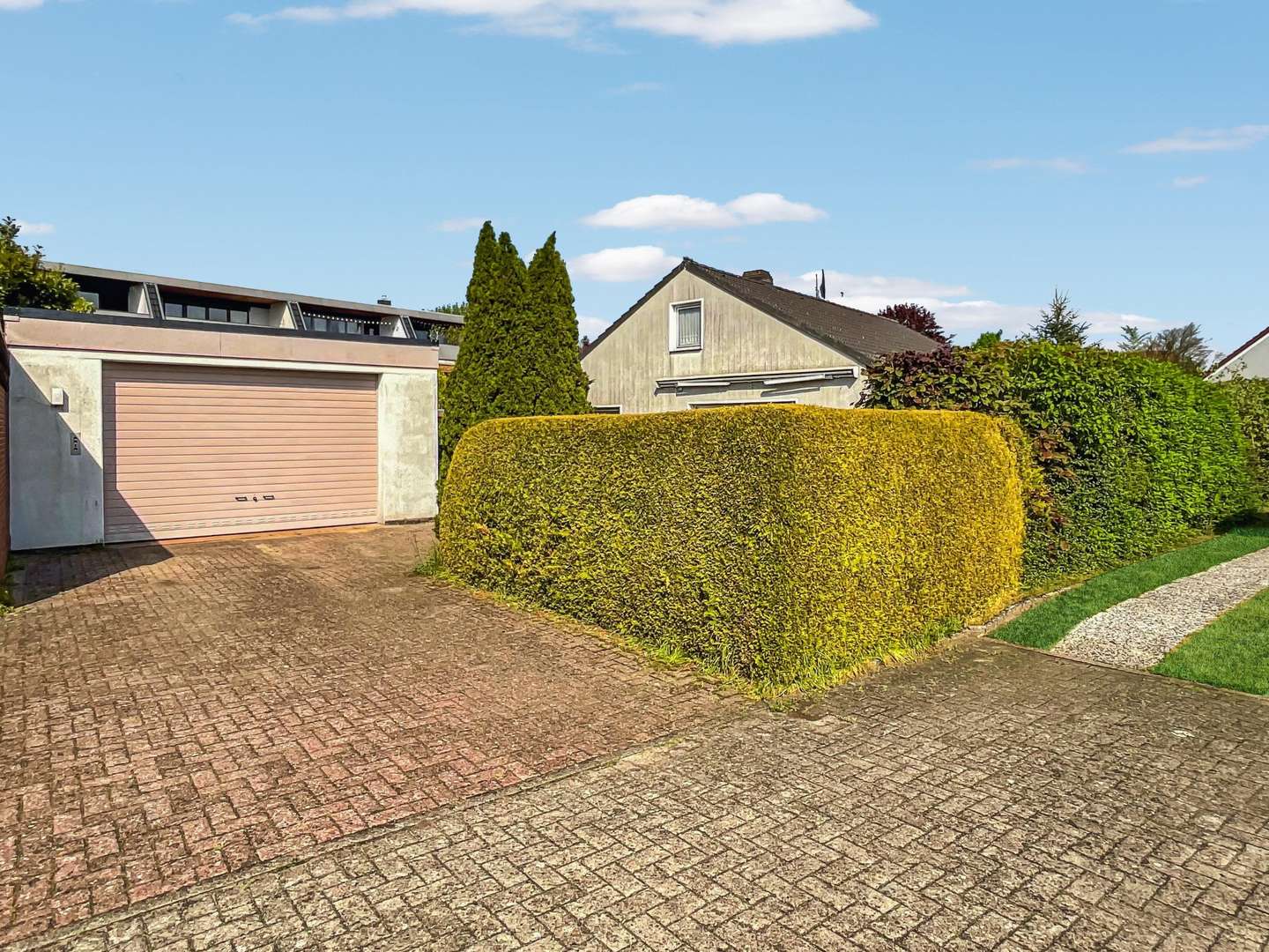 Blick auf die Garage und die Terrassenseite des Hauses - Einfamilienhaus in 28832 Achim mit 100m² kaufen