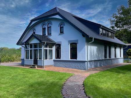 Giebelansicht mit Terrasse - Zweifamilienhaus in 27639 Wurster Nordseeküste mit 262m² kaufen