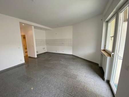 Das Wohnzimmer mit offener Küche und Balkonzugang. - Erdgeschosswohnung in 40211 Düsseldorf mit 57m² kaufen