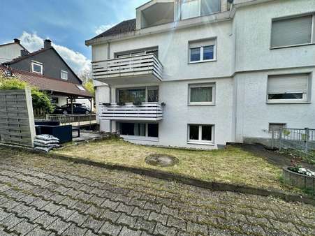 Grünfläche und Rückansicht - Souterrain-Wohnung in 44289 Dortmund mit 88m² kaufen