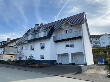 Straßenansicht mit Balkon und Garagen - Zweifamilienhaus in 57319 Bad Berleburg mit 232m² kaufen