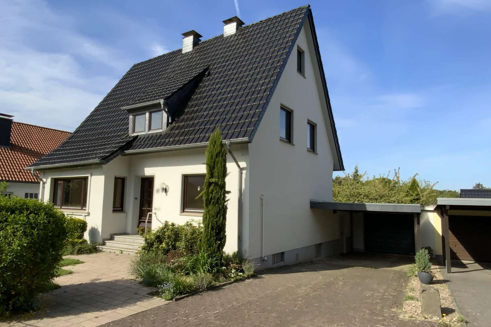 Vorderansicht mit Zuwegung und Garage - Einfamilienhaus in 32791 Lage mit 110m² kaufen