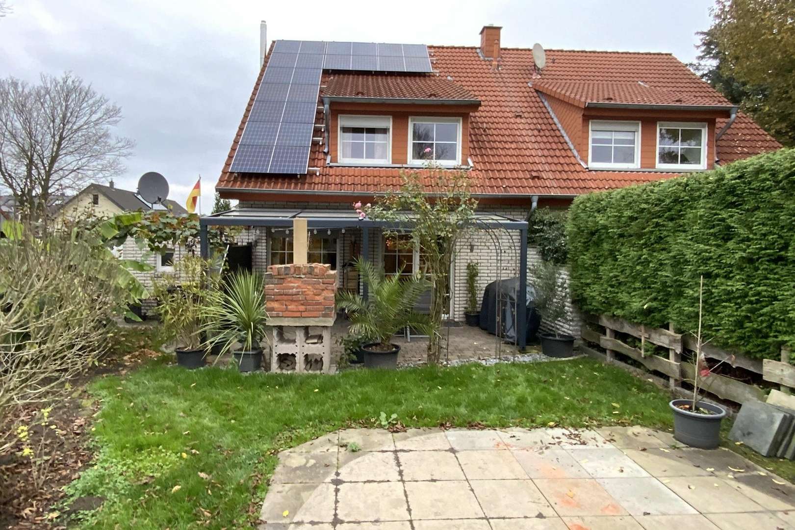 Blick vom Garten auf die überdachte Terrasse  3:2 - Zweifamilienhaus in 33813 Oerlinghausen mit 126m² kaufen