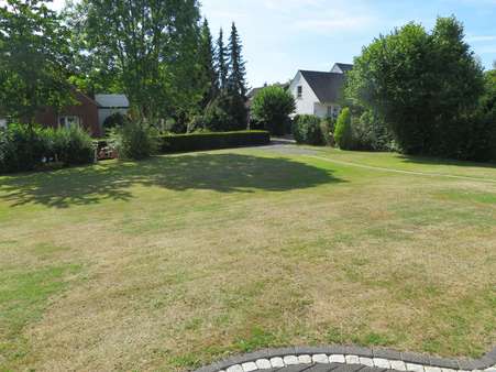 Rasenanlage mit Blick auf hintere Grundstückszufahrt - Zweifamilienhaus in 32549 Bad Oeynhausen mit 256m² günstig kaufen