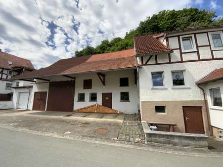 Ansicht mit Nebengebäuden und Garage - Einfamilienhaus in 34516 Vöhl mit 156m² kaufen