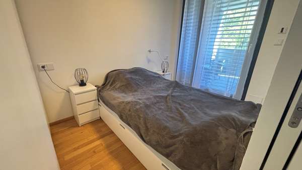 Schlafzimmer mit Bett und Blick Richtung Balkon - Erdgeschosswohnung in 71679 Asperg mit 28m² kaufen