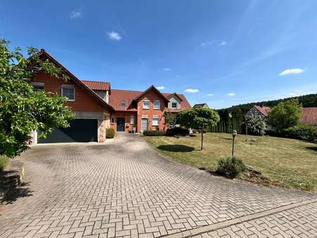 Westansicht mit Eingang und Zufahrt zur Garage Westansicht mit Eingang und Zufahrt zur Garage - Einfamilienhaus in 97496 Burgpreppach mit 340m² kaufen