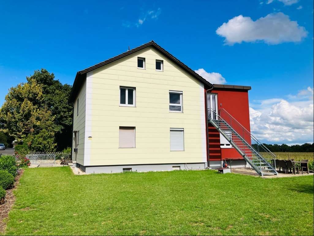 Westansicht mit großer, ebener Gartenfläche - Zweifamilienhaus in 97531 Theres mit 150m² kaufen