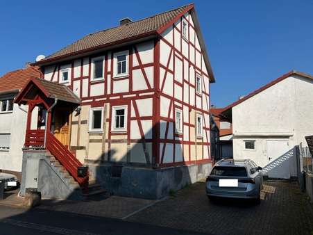 Eingangsseite, Stellplatz und Nebengebäude - Einfamilienhaus in 34576 Homberg mit 130m² kaufen